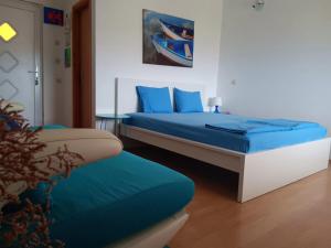 a bedroom with two beds with blue pillows at Art room JASMINA with sea view - Bikers and pets are welcome in Starigrad-Paklenica