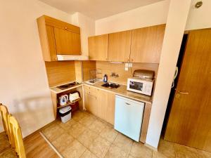 a kitchen with wooden cabinets and a white refrigerator at Todorini Kuli Apartments in Bansko +190 photos