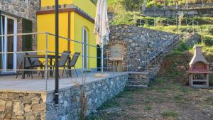 a patio with a table and chairs and a building at Vento di Mare - Tramontana con piscina in Moneglia