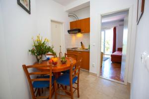 a kitchen and dining room with a wooden table and chairs at Villa Ankora Apartments Tučepi in Tučepi +92 photos