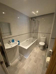a bathroom with a tub and a sink and a toilet at Lot 1 The Old Auction Room in Whitby