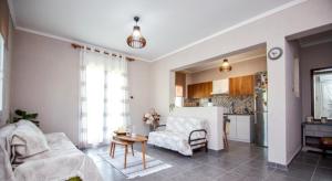 a living room with a couch and a table and a kitchen at Liopetra in Serres