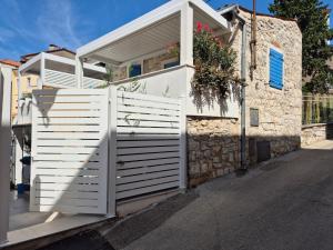a white privacy fence in front of a house at Old Stone Holiday Home in Rovinj