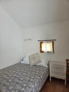 a small bedroom with a bed and a window at Saignon, Chambres d hôtes in Saignon