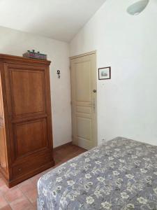 a bedroom with a bed and a wooden cabinet at Saignon, Chambres d hôtes in Saignon +3 photos