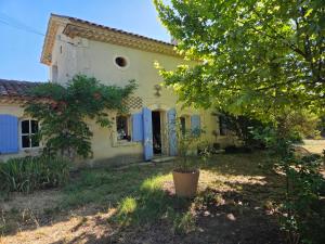 an old house with blue doors and a tree at Saignon, Chambres d hôtes in Saignon