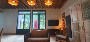 a living room with a couch and a window at Maison Normande au bord de rivière avec spa et sauna in Rugles