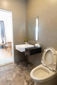 a bathroom with a toilet with a sink and a mirror at Pani House in Ban Nong Chaeng +20 photos