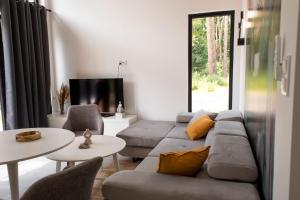 a living room with a couch and tables and a tv at Sosnowa Korona in Skorochow