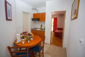 a kitchen and a table with a bowl of fruit on it at Apartments Ankora in Tučepi