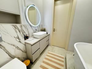 a white bathroom with a sink and a mirror at 4х комнатная Премиум класс возле Хан шатыра in Astana