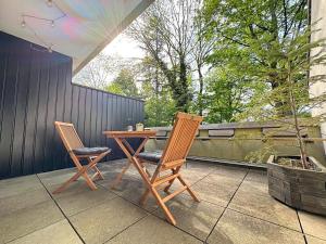 two chairs and a wooden table on a patio at Kleine BergZeit in Sankt Andreasberg