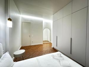 a white bedroom with a bed and a cabinet at 4х комнатная Премиум класс возле Хан шатыра in Astana