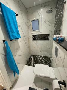 a bathroom with a white toilet and a blue towel at Endless Summer Apartment House W7 in Safaga  +11 photos