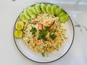 a plate of food with shrimp and rice and cucumbers at Pani House in Mae Rim