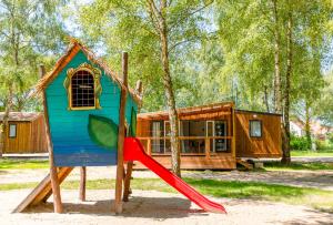 a house with a slide in front of a cabin at Camping ClicoChic Au Clair Ruisseau in Gerstheim