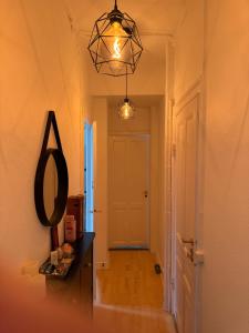 a hallway with a mirror and a light fixture at Nordhavn Cozy Room in shared apartment in Copenhagen
