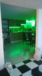 una cucina con illuminazione verde e tavolo e sedie di Domek Agroturystyczny Doris a Stężyca Altre 7 foto