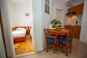 a small kitchen and dining room with a table and chairs at Villa Ankora Apartments Tučepi in Tučepi
