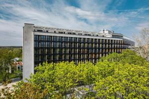 a large office building with trees in front of it at Aparthotel Nemunas in Druskininkai