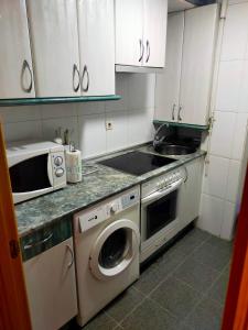 a kitchen with a washing machine and a microwave at Bienvenidos in Burgos