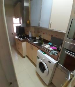 a kitchen with a washing machine and a sink at Westend renting 2 bed Sagrada Família in Luanda +5 photos