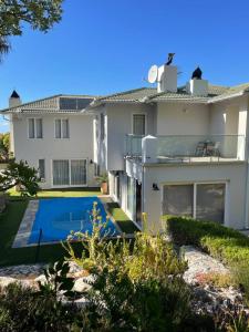a house with a swimming pool in front of it at Sea 'n Summit Hermanus in Hermanus