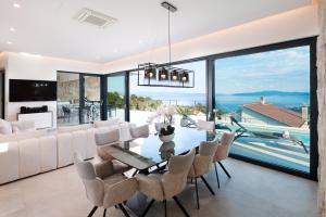 ein Wohnzimmer mit Esstisch und Stühlen in der Unterkunft Villa Agapanthus in Veprinac