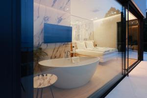 ein Bad mit einer großen Badewanne und einem Bett in der Unterkunft Villa Agapanthus in Veprinac