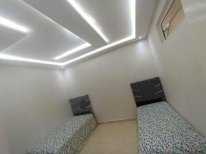 two beds in a room with a ceiling at Appartement a Oued laou complexe cité cinter in Oued Laou +1 photo