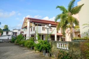 a street in front of a building with palm trees at The Teak Ambalangoda in Ambalangoda