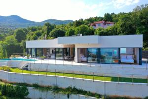 ein Haus auf einem Hügel mit einem Swimmingpool in der Unterkunft Villa Agapanthus in Veprinac