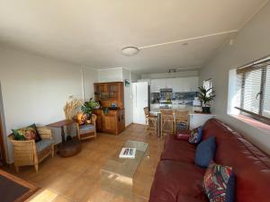 Una sala de estar con un sofá y una cocina. en Kom Surf Studio, en Kommetjie