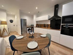 een keuken met een houten tafel met stoelen en een eetkamer bij Appartement entier Cosy in Grenoble