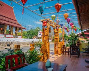 a patio with a table and colorful lanterns at PP Guesthouse LPB in Luang Prabang