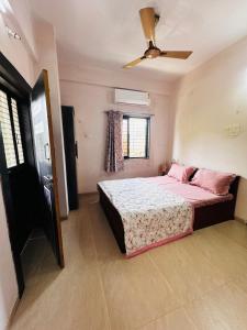 a bedroom with a bed and a ceiling fan at Snehal's Homestay Hosting Only Families in Nashik