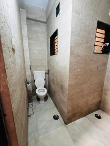 a small bathroom with a toilet and a window at Snehal's Homestay Hosting Only Families in Nashik