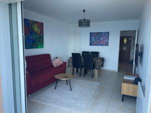 a living room with a red couch and a table at Appartement première ligne in Collioure