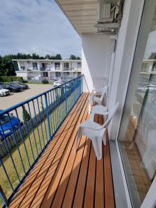 a balcony with a white bench on a deck at Pylimo 59 in Šventoji