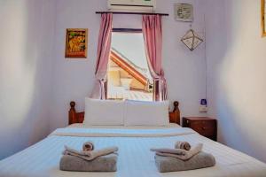 a bedroom with a bed with two towels on it at PP Guesthouse LPB in Luang Prabang