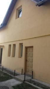 ein weißes Haus mit einer Tür und einem Zaun in der Unterkunft Leonardo GuestHouse Available in Sibiu