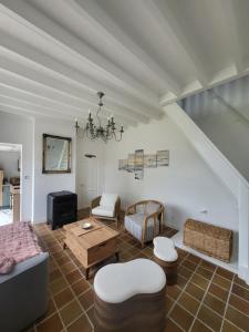 ein Wohnzimmer mit Sofa und Tisch in der Unterkunft La petite maison blanche in Dunkerque