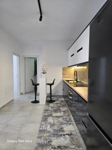 una cucina con lavandino e bancone con tavolo di Luxury Apartment a Durrës