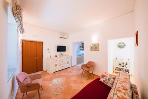 a living room with a couch and chairs and a tv at Smeraldo Holiday House in Conca dei Marini