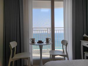 a room with a table and chairs and a view of the ocean at Ocean Stay Yangyang in Yangyang