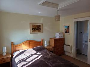 ein Schlafzimmer mit einem Bett und einem Waschbecken darin in der Unterkunft Old School Cottage in Toller Porcorum