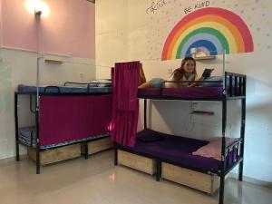 a woman laying on top of three bunk beds at Wake Up Weligama in Weligama