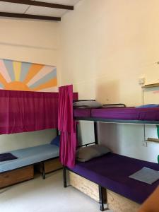 two bunk beds in a room with purple curtains at Wake Up Weligama in Weligama