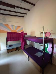 two bunk beds in a room with a mural at Wake Up Weligama in Weligama