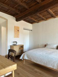 a bedroom with a bed and a desk and a table at Domagiho in Bedigliora